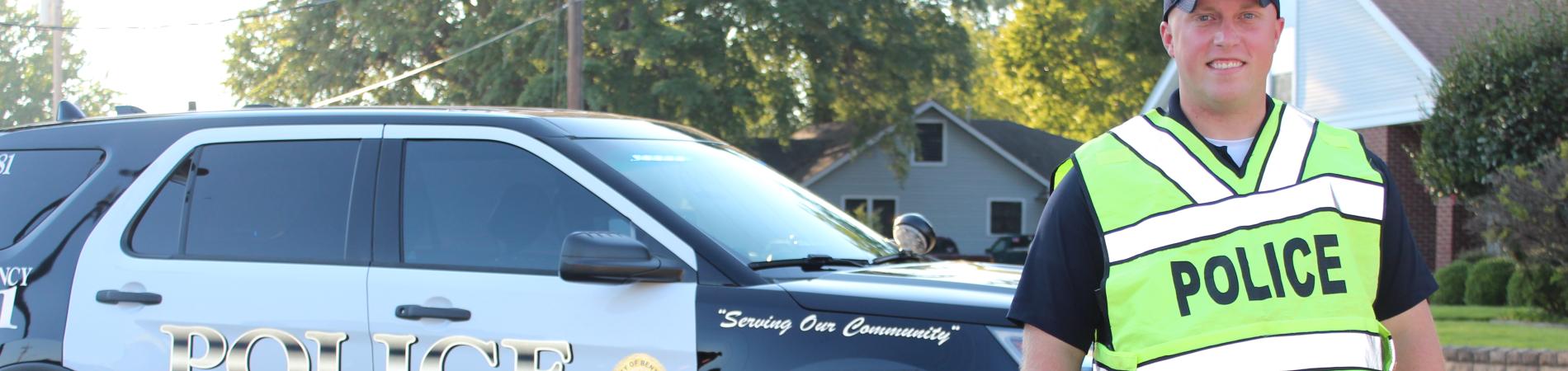 Officer with vest next to car